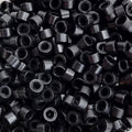 Close up of salon professional silicon lined aluminium Black micro beads used as an anchor for weave hair extensions. The silicone lining provides extra grip and acts as a soft, protective layer between the bead and natural hair.